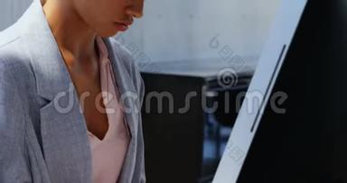非洲裔美国女商人在一间<strong>现代</strong>化办公室的<strong>办公桌</strong>上电脑工作的侧视图